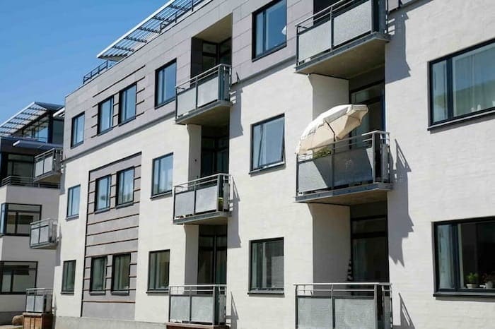 zuverlässige Sonnenschutzmaßnahmen: Bild zeigt sonnige Hausfassade mit Balkonen 