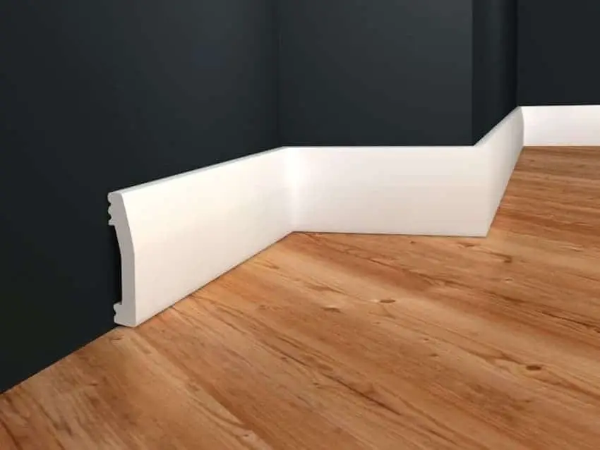 Warum sind Sockelleisten so wichtig? 1 Warum sind Sockelleisten so wichtig? Bild zeigt Holzboden, der von weißer Sockelleiste vor schwarzer Wand eingefasst ist