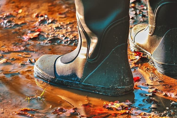 Schutz vor Hochwasser Bild zeigt Gummistiefel im Matsch