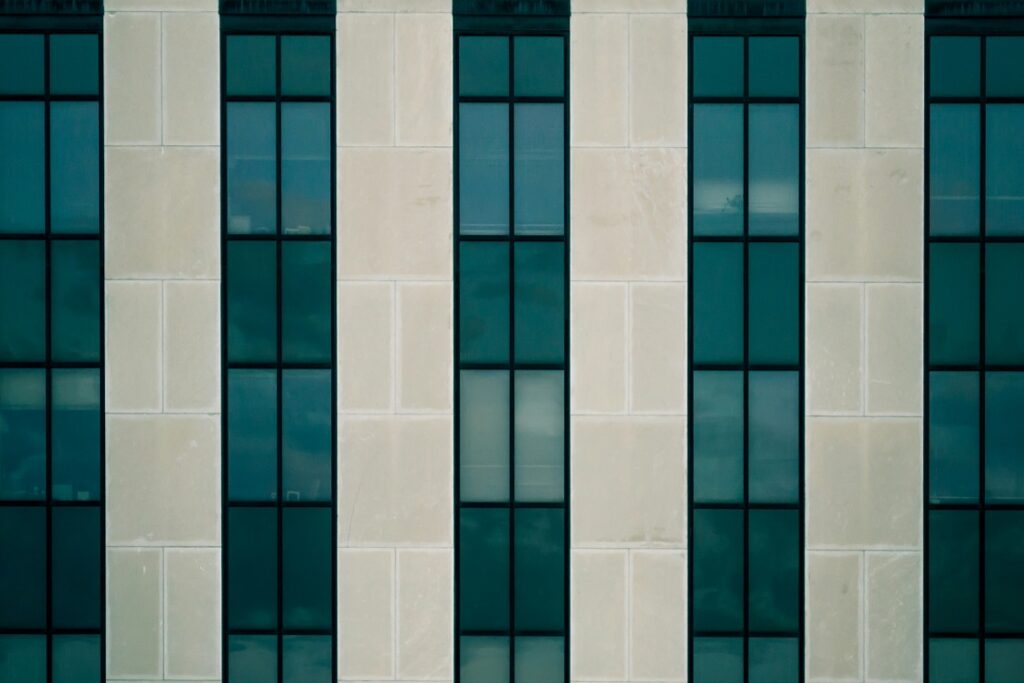 Aluminiumfenster: Bild zeigt Hausfassade mit großen bodentiefen blau getönten Aluminiumfenstern