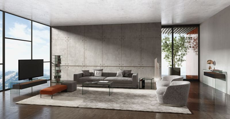 Gemütlichkeit geht auch in modernen Wohnungen: Graue Couch vor grauer Betonwand mit Glastisch