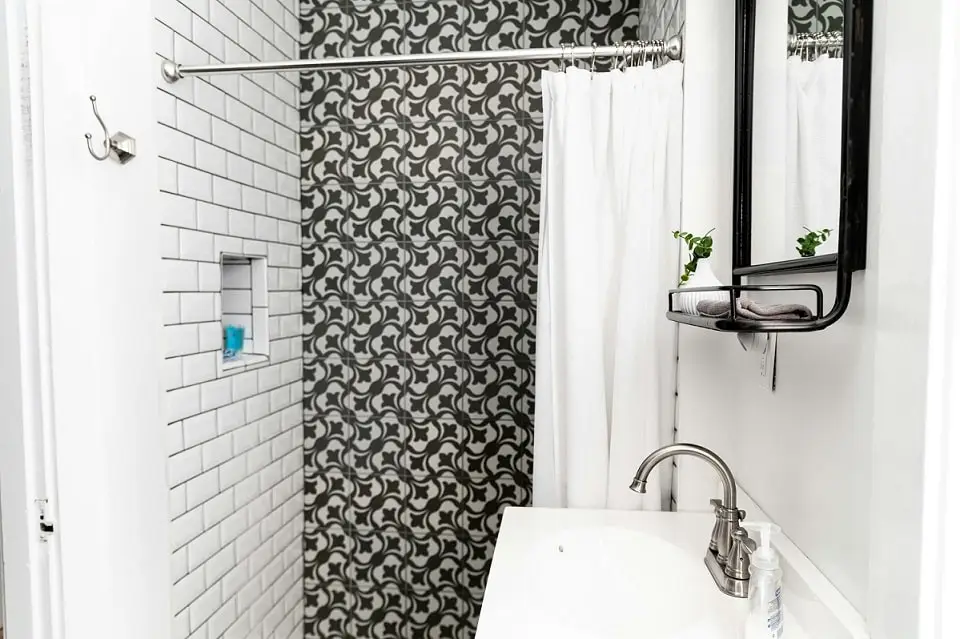 Teilmöbliert vermieten – Miete für Möbel richtig berechnen 2 teilmöbliert vermieten: Bild zeigt Dusche mit Duschstange, Duschvorhang und weißem Spiegel mit Ablage oberhalb Waschtisch
