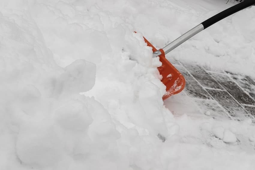 Winterdienst & Schneeräumpflichten Bild zeigt Schneeschippe mit Schnee