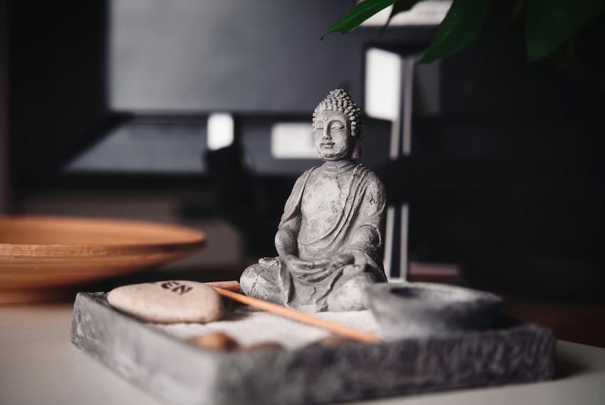 Wohnung einrichten: Tipps fürs Schlafzimmer: Bild zeigt kleine meditierende Buddhafigur auf einem Tablett
