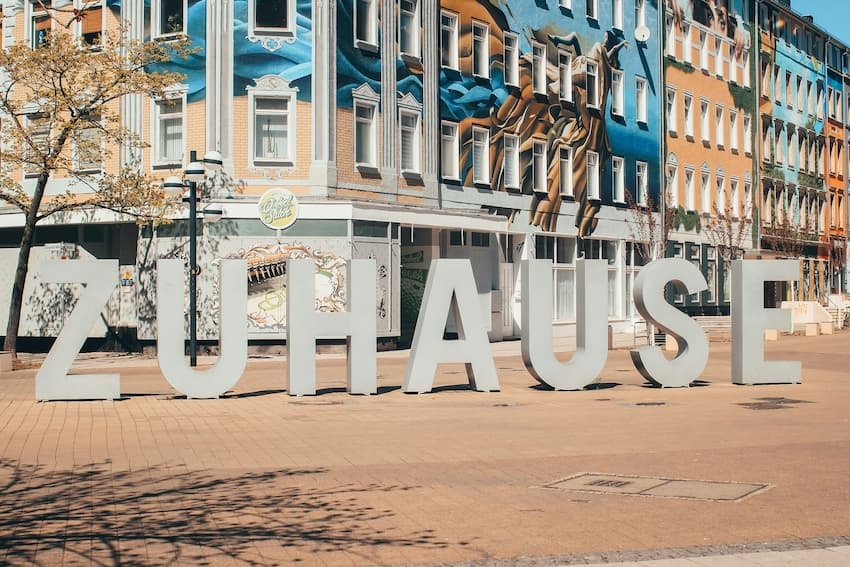 wo mieten besonders günstig ist: Bild zeigt bunte Häuserfassade in Chemnitz, davor sind Buchstaben aufgestellt, die das Wort zuhause bilden.