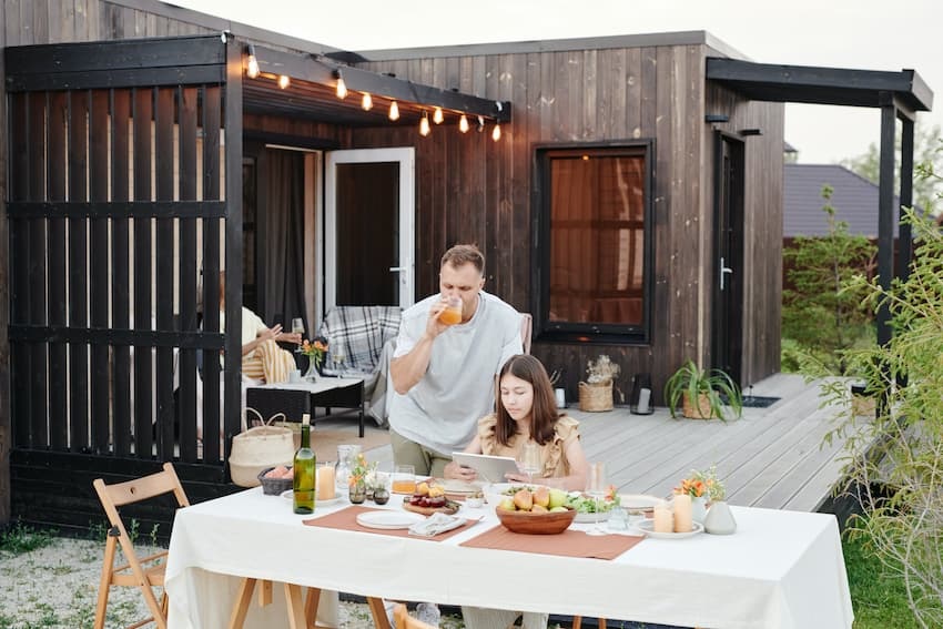 Terrassengestaltung: Lieblingsort Terrasse, Bild zeigt Familie auf Terrasse mit gedecktem Tisch