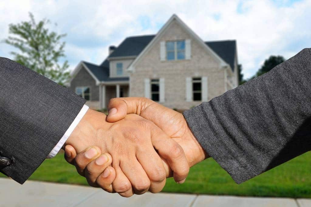 Wohnung kaufen mit Bankkredit -welche Bank passt? 1 Wohnung kaufen mit Bankkredit:
Bild zeigt Handschlag vor Einfamilienhaus