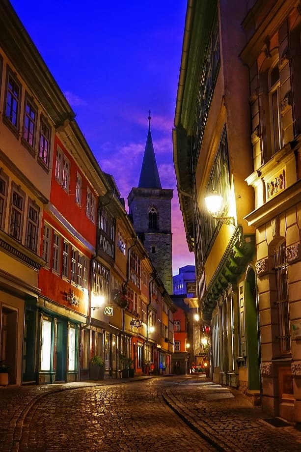Bild zeigt Kneipenviertel in Erfurt bei Nacht mit beleuchteten Altstadthäusern an Pflasterstraße.