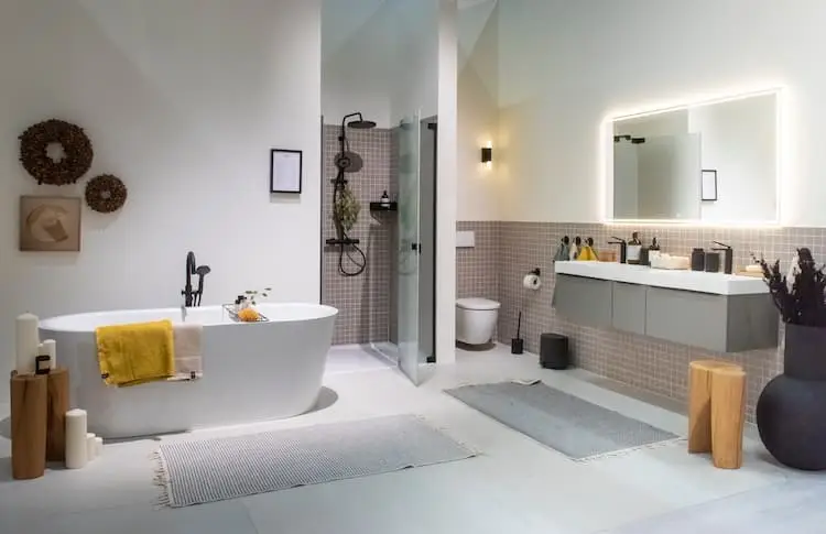 5 Wohntrends rund um Deine Wohnung 5 5 Wohntrends rund um Deine Wohnung Bild zeigt Badezimmer in den Farben weiß mit schwarzen Armaturen und Holzdeko sowie grau-violetten Fliesen