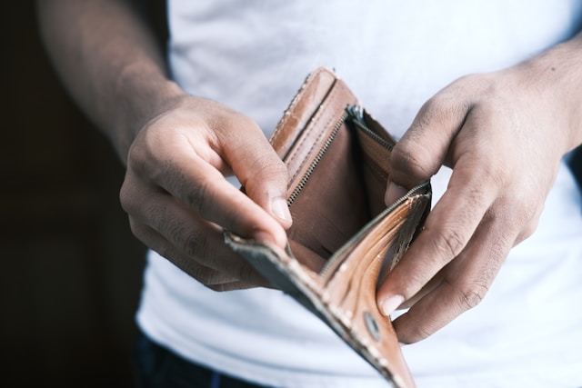 Wege aus der Schuldenfalle Bild zeigt leere Geldbörse gehalten von 2 Händen